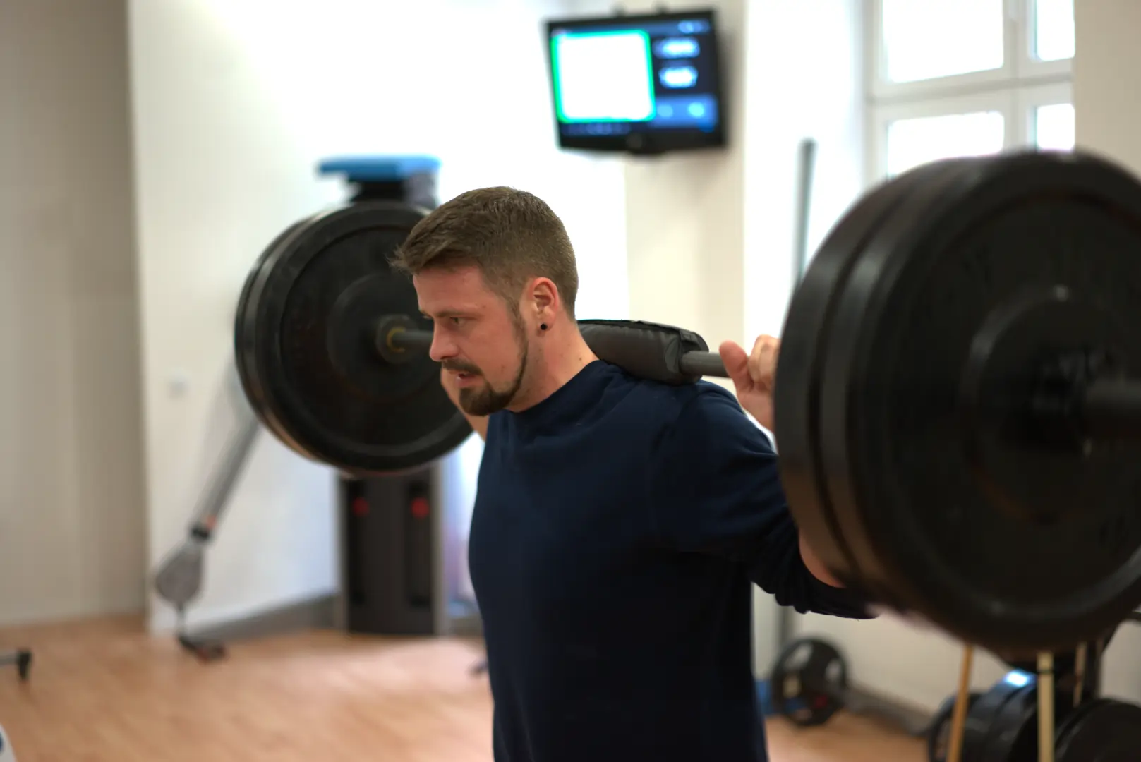Kunde beim Personaltraining der Squads mit der Langhantel macht.