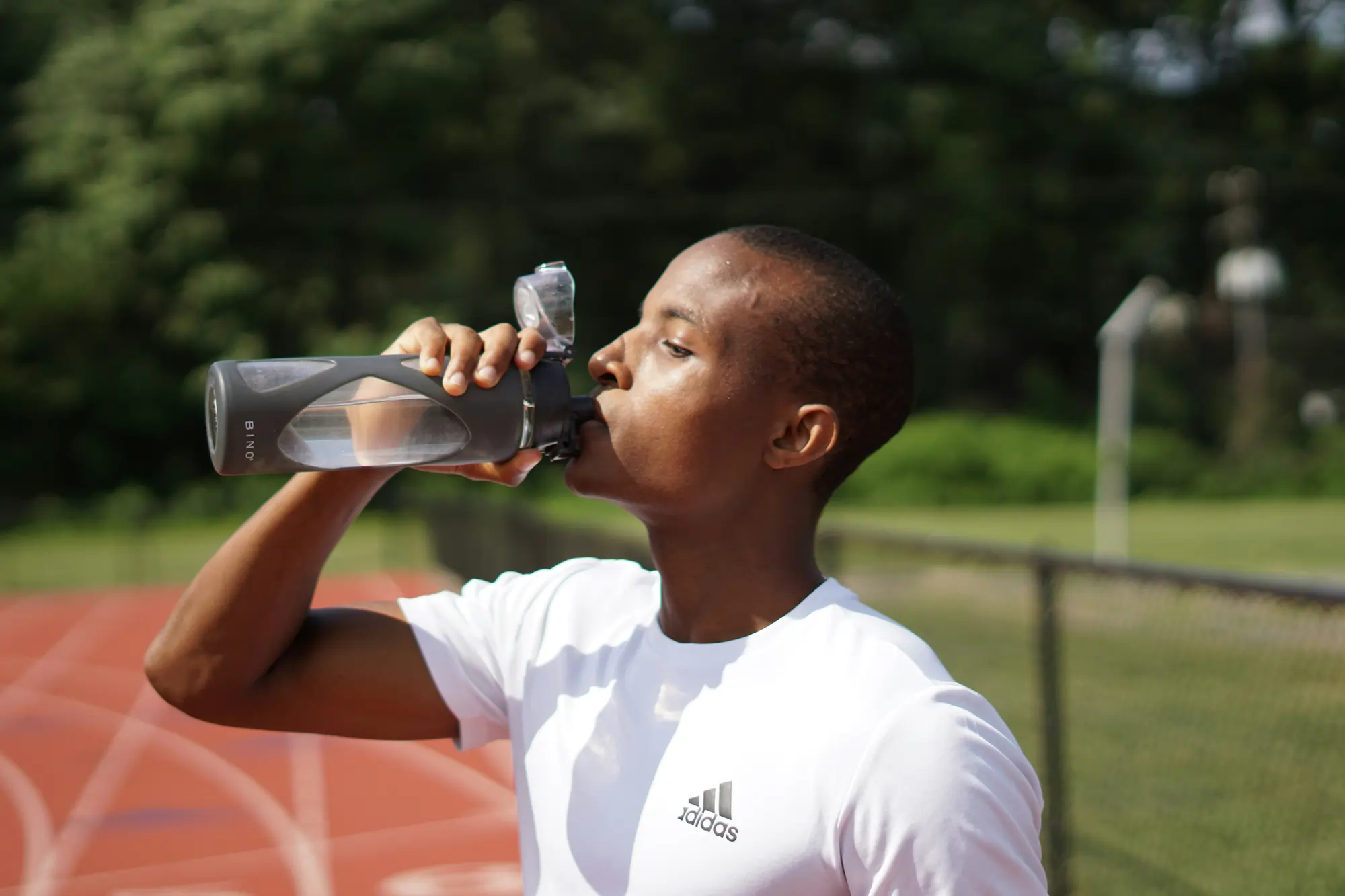 Ein Sportler der Wasser Trinkt